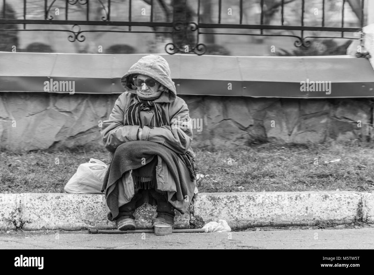 Una vecchia donna supplica per la ALMS dalla strada. Foto in bianco e nero. Foto Stock