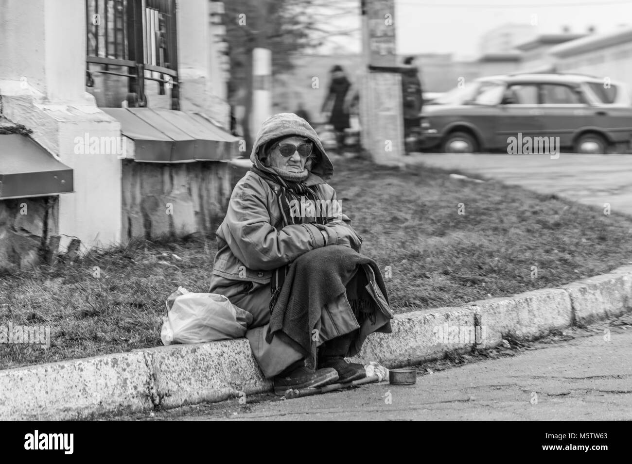 Foto in bianco e nero di una donna a mendicare per passanti Foto Stock