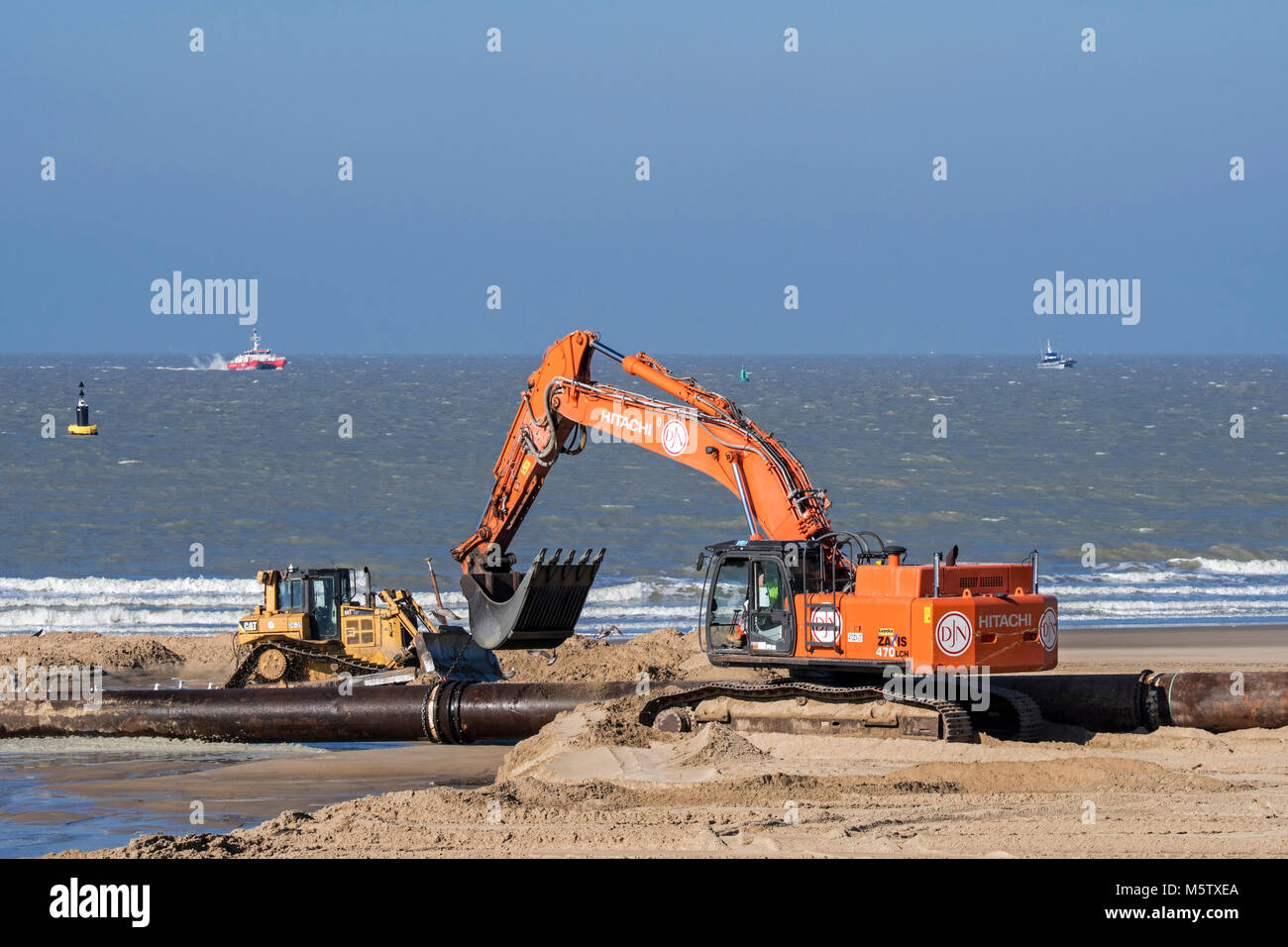 Escavatore idraulico delle tubazioni di collegamento della tubazione durante il rifornimento di sabbia / spiaggia nutrimento lavora lungo la costa belga di Ostenda, Belgio Foto Stock