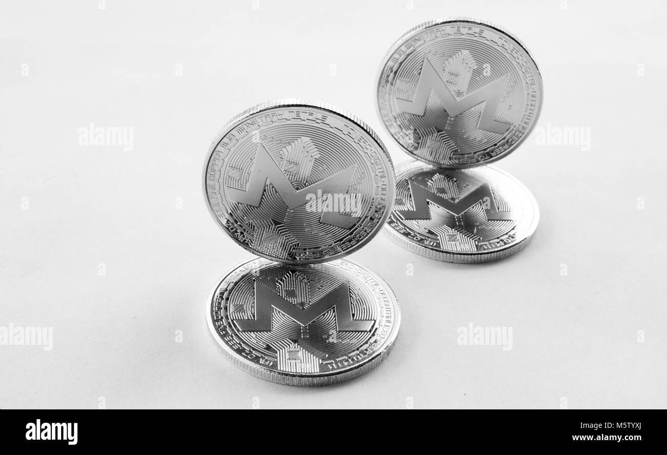Su uno sfondo bianco sono monete d'argento di un digital crypto moneta - monero. In aggiunta alla giacente monete, vi sono monero permanente. Vista da ab Foto Stock