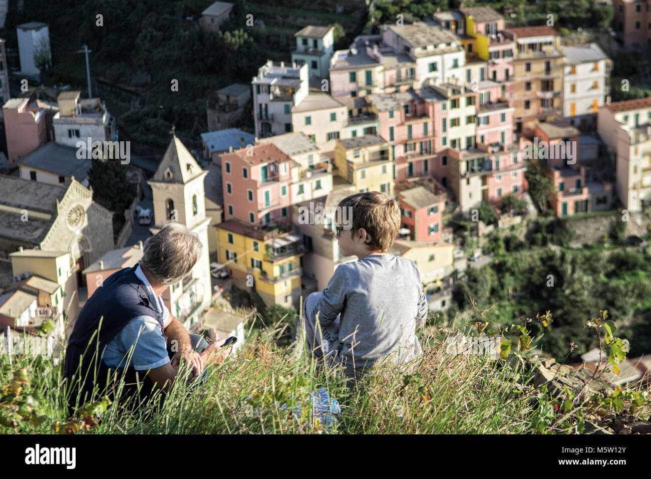 Uomo e Ragazzo che guarda al villaggio di Manarola, il Parco Nazionale delle Cinque Terre, Liguria, Italia Foto Stock