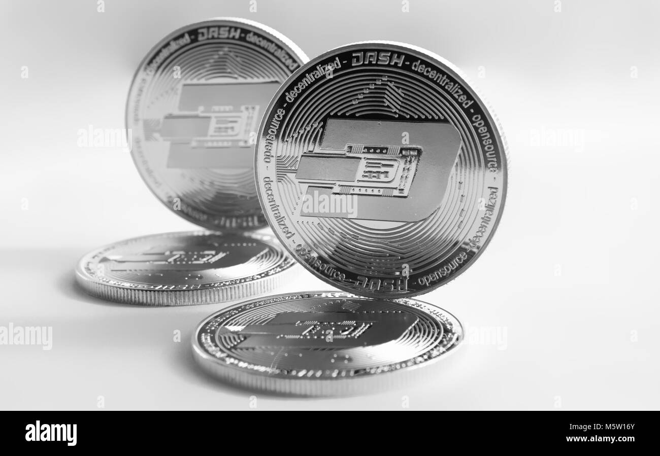 Nella foto sono monete d'argento di un digital crypto moneta - dash. In aggiunta alla giacente monete, vi sono monete permanente dash. Lo sfondo è grigio. Foto Stock