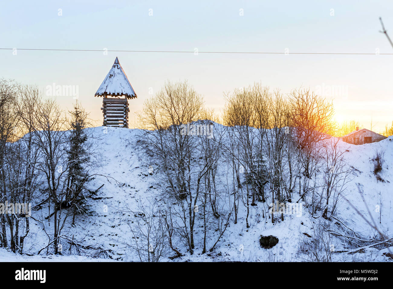 In legno torre di vedetta sorge su una montagna innevata. Paesaggio invernale al tramonto. Decorazioni di vecchie fortificazioni russe in Funny Nicholas Fortezza Foto Stock