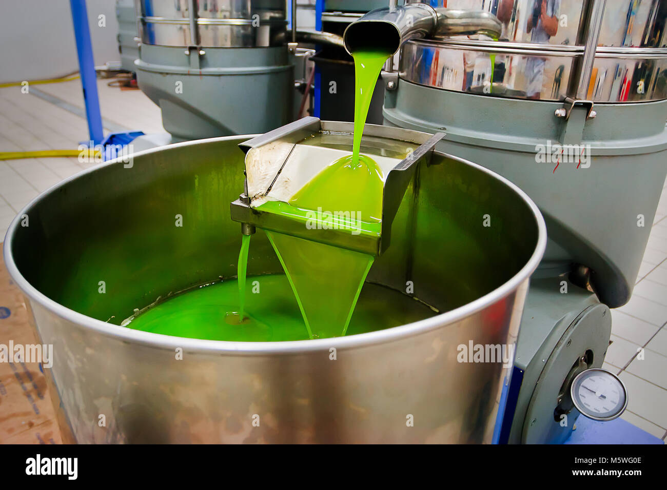 Di piccole dimensioni ma moderno produttore di alta qualità olio extra vergine di oliva. Il primo olio comincia a solleticare attraverso questo equipaggiamento siciliana. Foto Stock