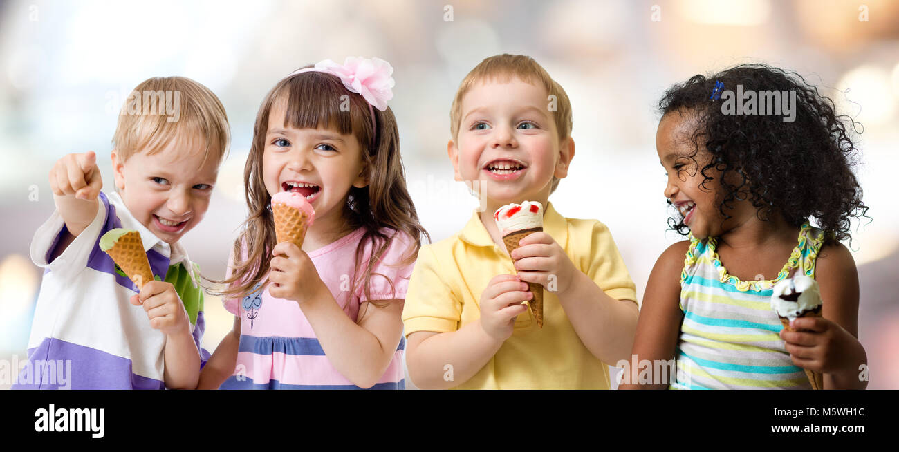 Felice gruppo di bambini a mangiare il gelato in un party in cafe Foto Stock