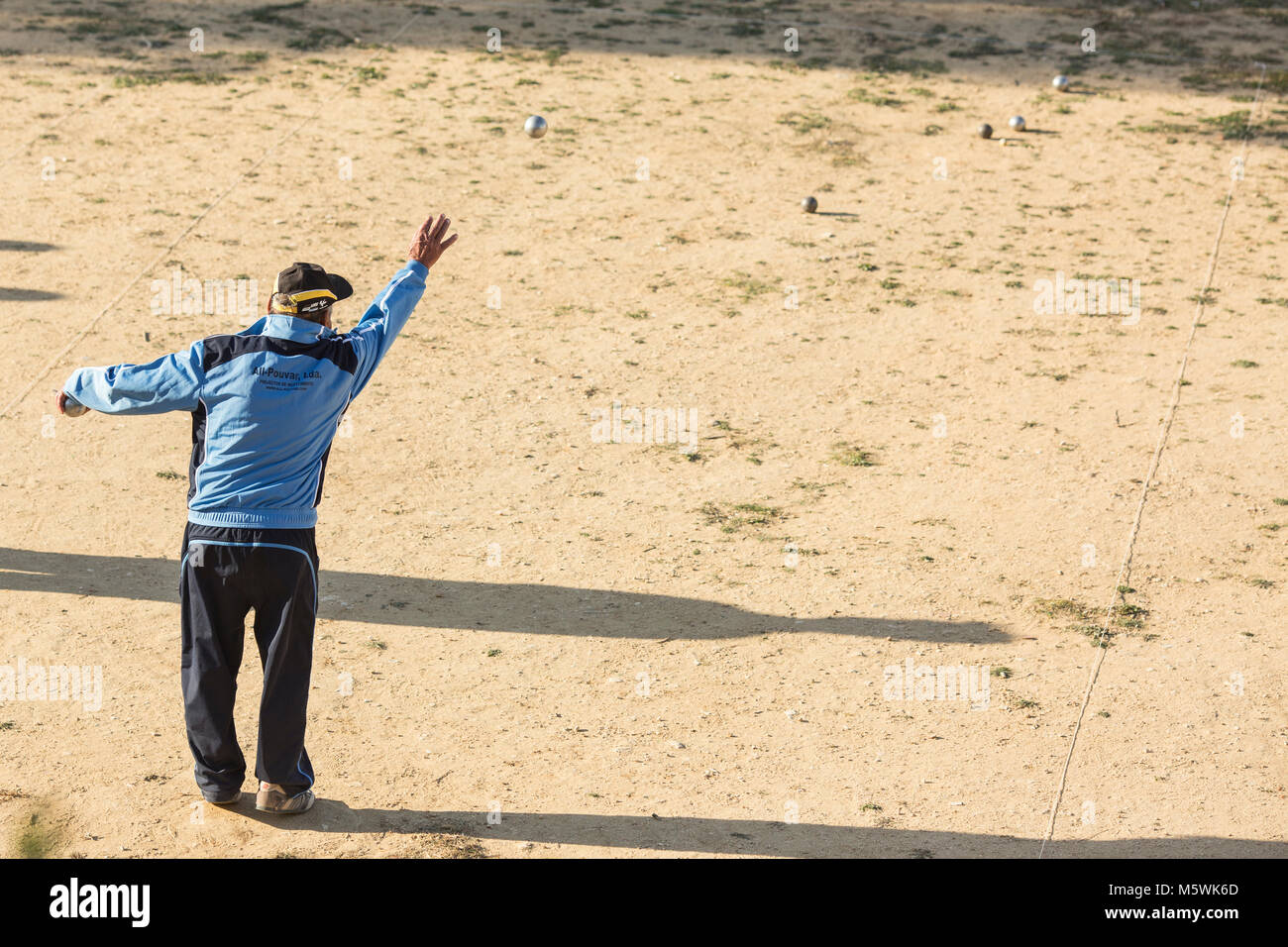 Lagos, Algarve, Portogallo - Febbraio, 25, 2018: Senior uomo gettando petanque palla. Foto Stock