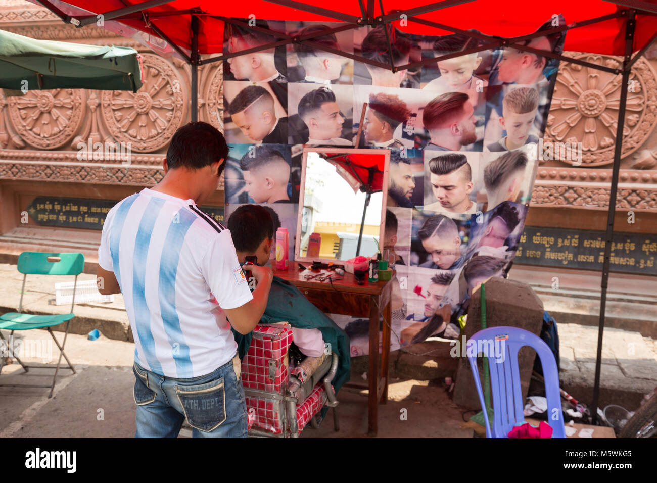 Mens parrucchiere che lavora in una stalla stradale, Phnom Penh Cambogia Asia Foto Stock