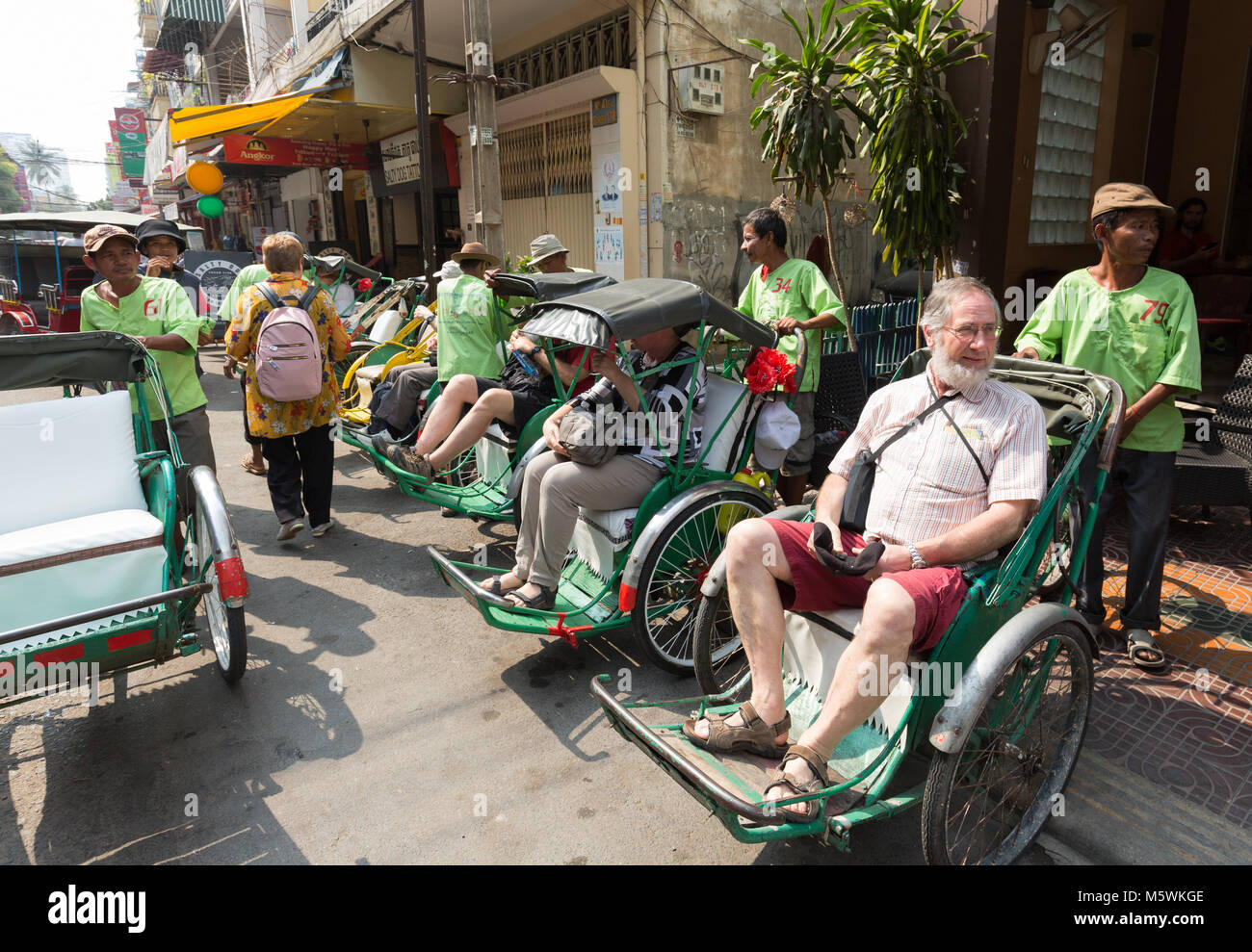 Turismo maturo seduto in un ciclo, una forma di taxi bicicletta, Phnom Penh Cambogia Asia Foto Stock