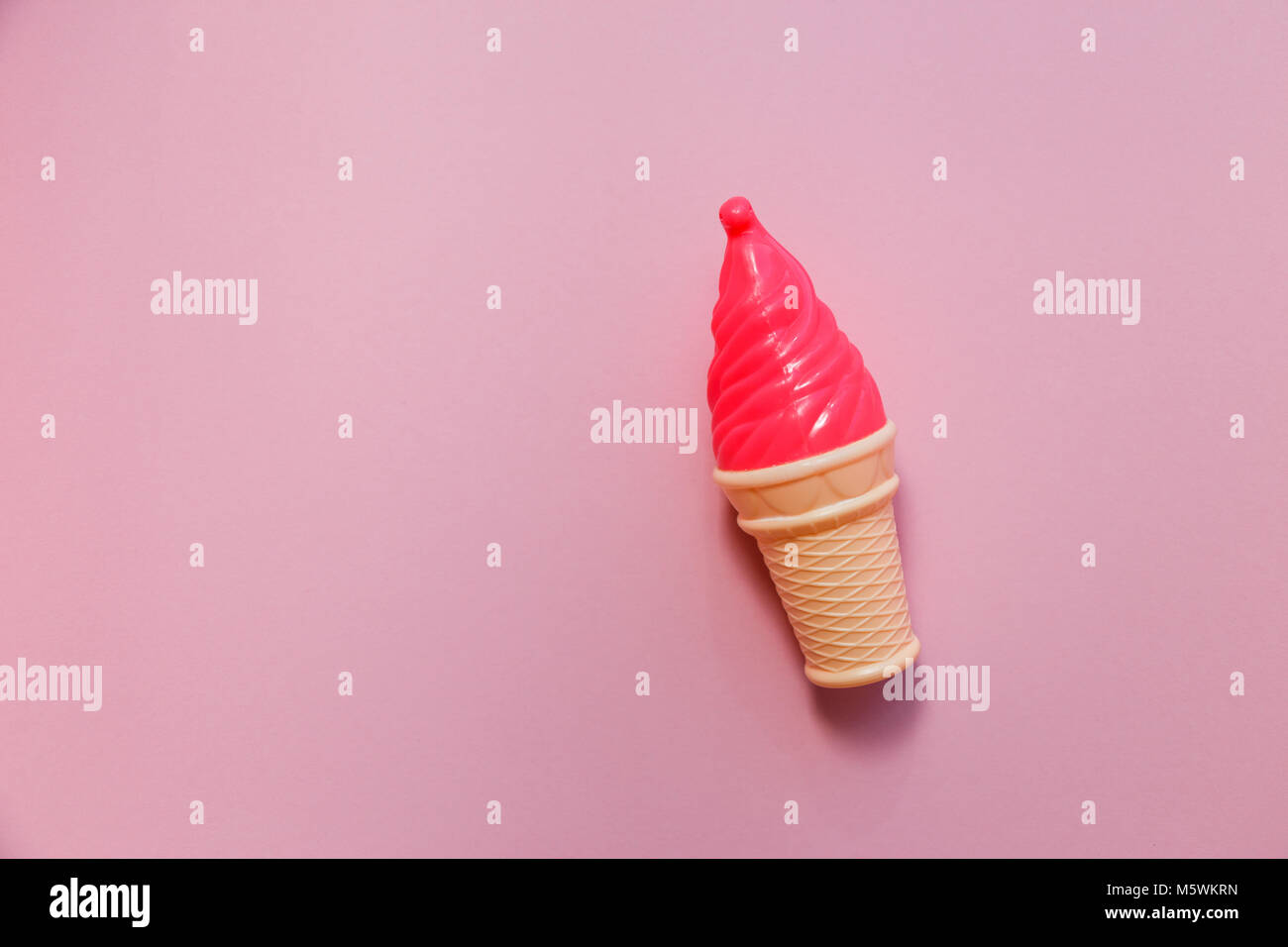 Fragola in plastica finto gelati su sfondo rosa Foto Stock
