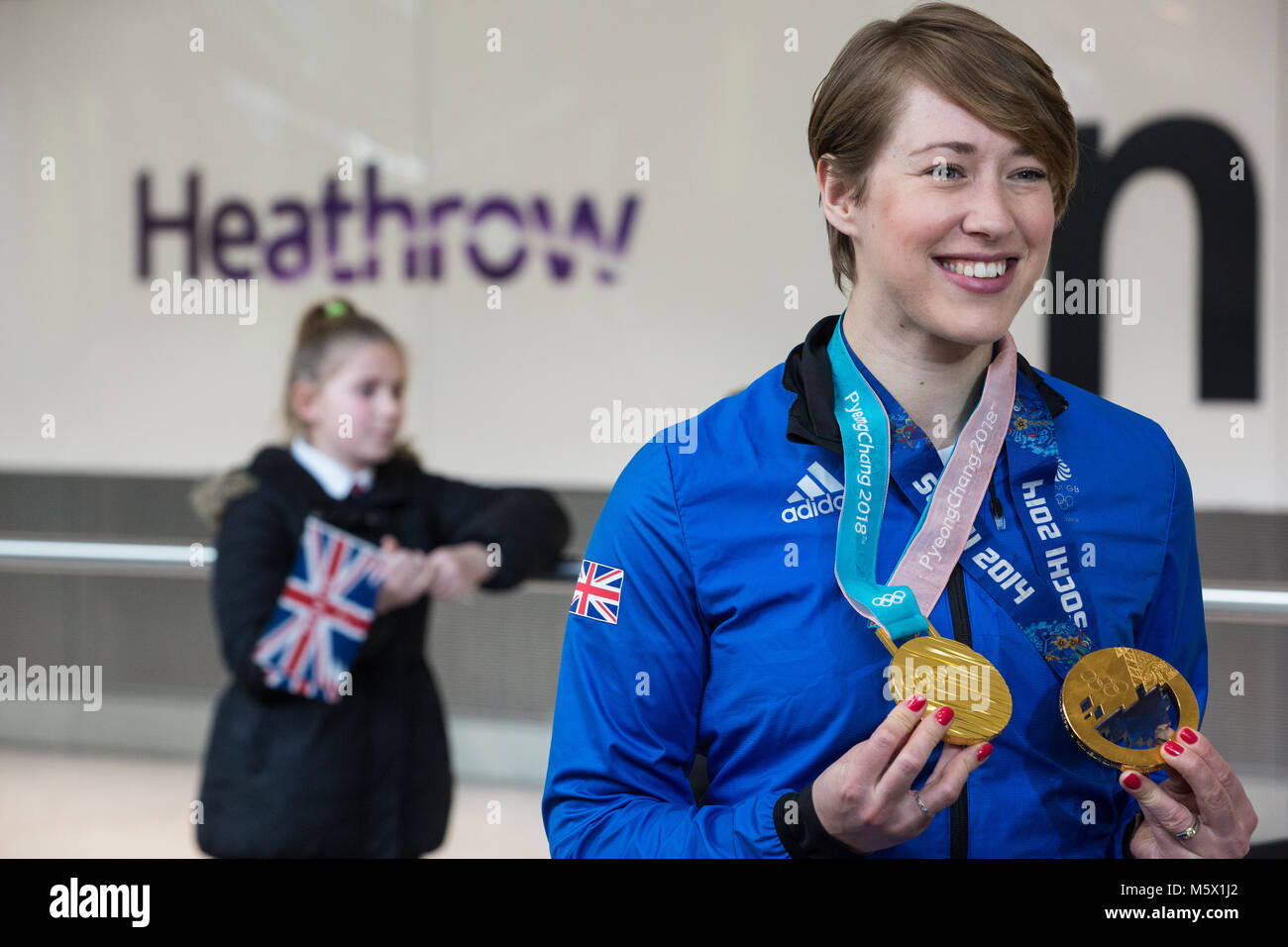 Londra, Regno Unito. Il 26 febbraio, 2018. Lizzy Yarnold visualizza le donne lo scheletro di medaglie di oro che ha vinto a Pyeongchang 2018 e Sochi 2014 come la British Olympic Association (BOA) accoglie favorevolmente Team GB atleti home da Pyeongchang 2018 Giochi Olimpici Invernali presso l'aeroporto di Heathrow. Lizzy Yarnold divenne il primo atleta britannico a difendere un Olimpiadi Invernali titolo. Credito: Mark Kerrison/Alamy Live News Foto Stock
