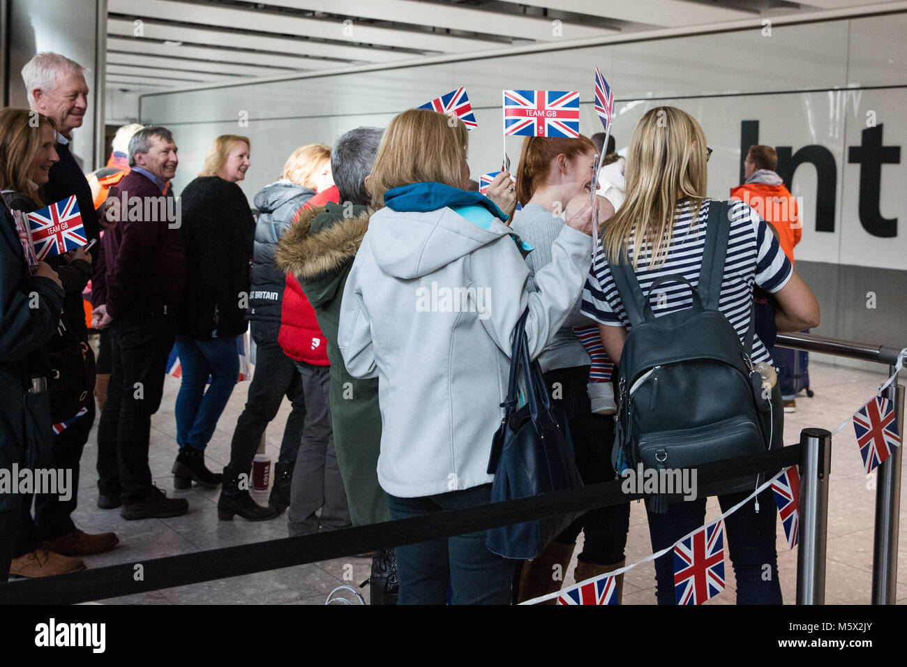 Londra, Regno Unito. Il 26 febbraio, 2018. I membri della famiglia di attendere per salutare il team GB membri di ritorno dal Pyeongchang 2018 Giochi Olimpici Invernali presso l'aeroporto di Heathrow. Credito: Mark Kerrison/Alamy Live News Foto Stock