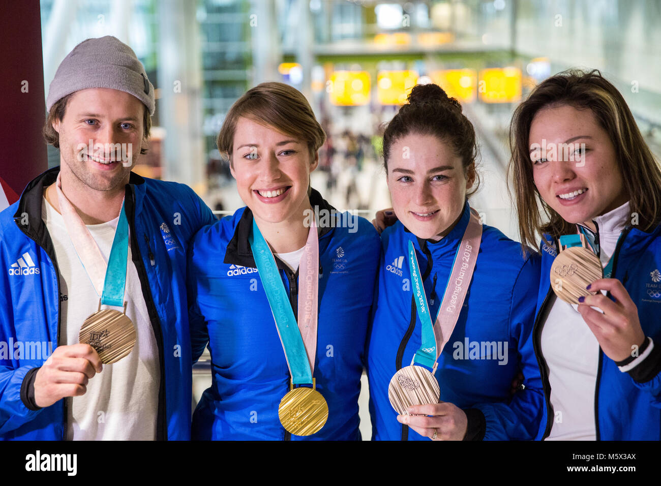 Londra, Regno Unito. Il 26 febbraio, 2018. Team GB vincitori di medaglie Billy Morgan, Lizzy Yarnold, Laura Deas e Izzy Atkin visualizzare le loro medaglie come la British Olympic Association (BOA) benvenuti gli atleti a casa dal Pyeongchang 2018 Giochi Olimpici Invernali presso l'aeroporto di Heathrow. Credito: Mark Kerrison/Alamy Live News Foto Stock