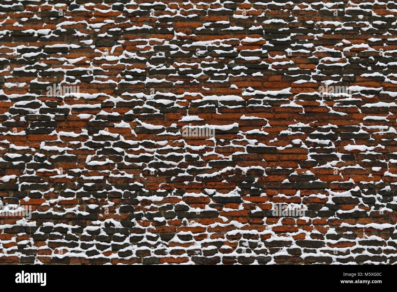 La neve sul vecchio muro in mattoni Foto Stock