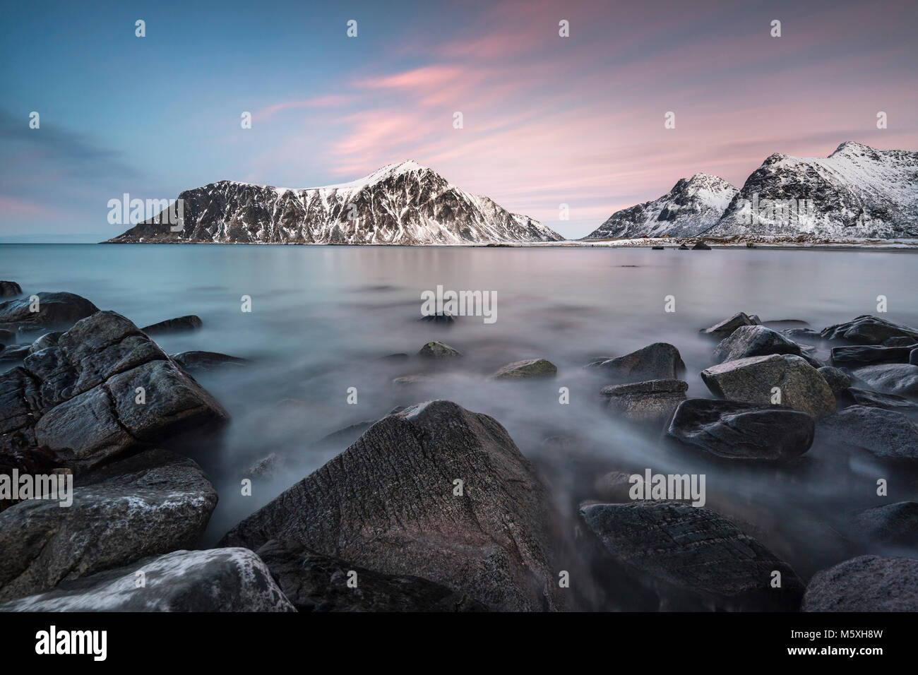 Costa rocciosa, montagne sullo sfondo, Skagsanden Beach, Lofoten, Norvegia Foto Stock