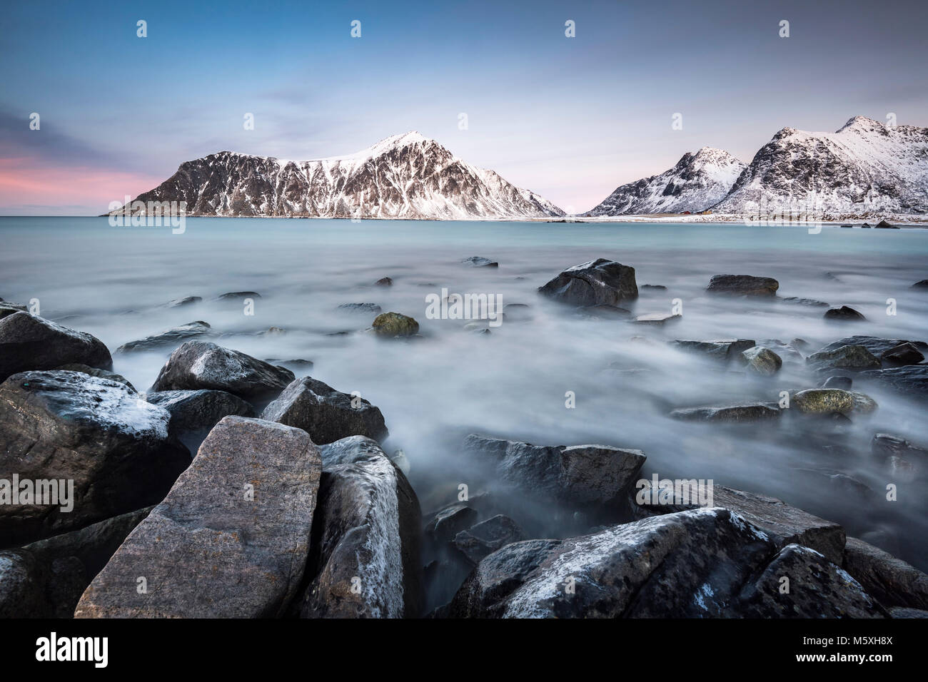 Costa rocciosa, montagne sullo sfondo, Skagsanden Beach, Lofoten, Norvegia Foto Stock