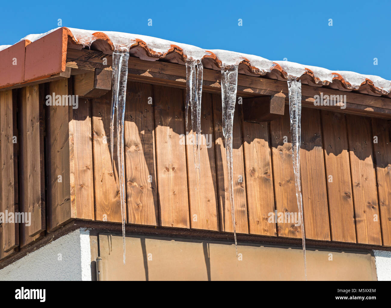 Ghiaccioli su un tetto al sole Foto Stock