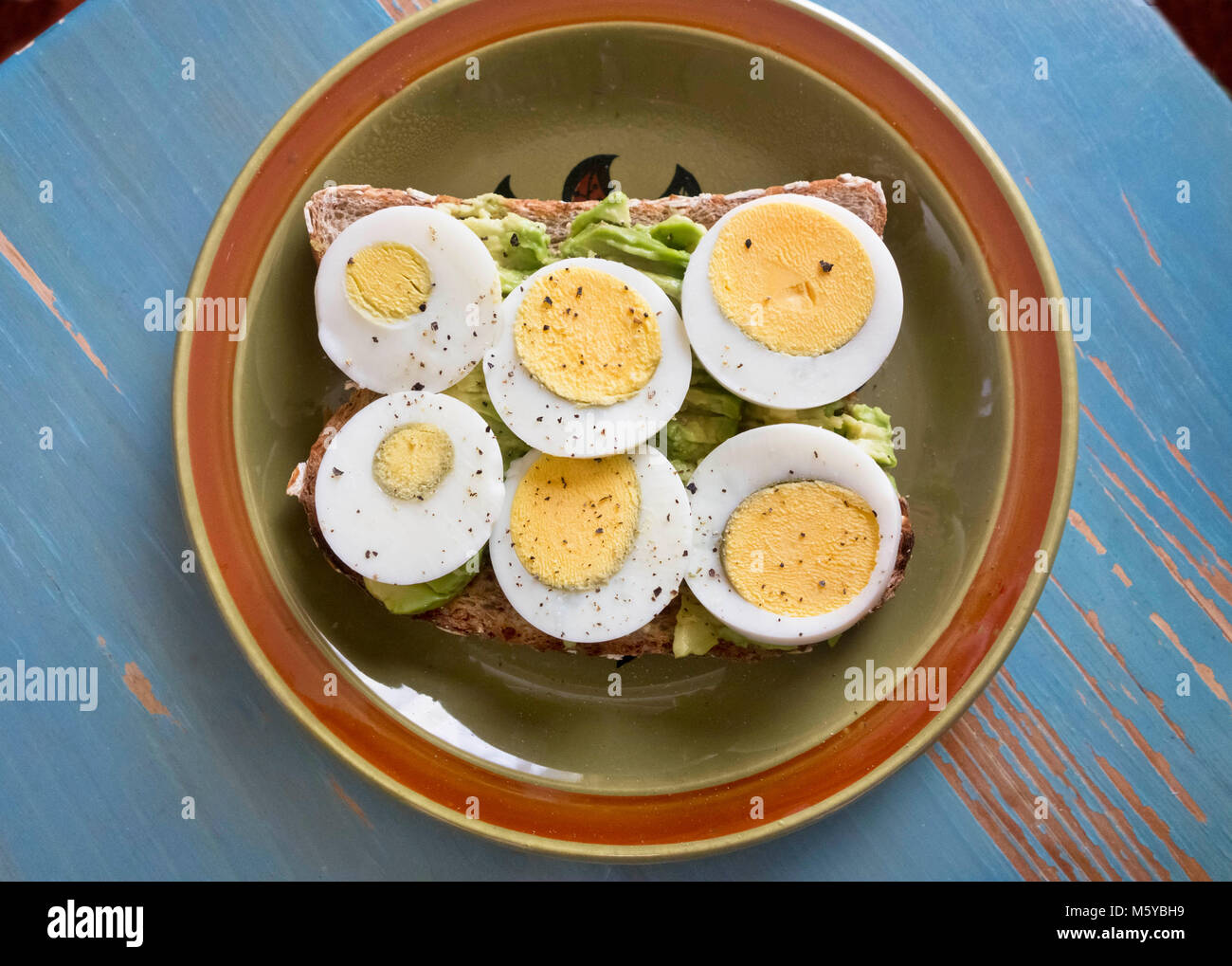 Uova sode a fette su toast con avocado. Foto Stock