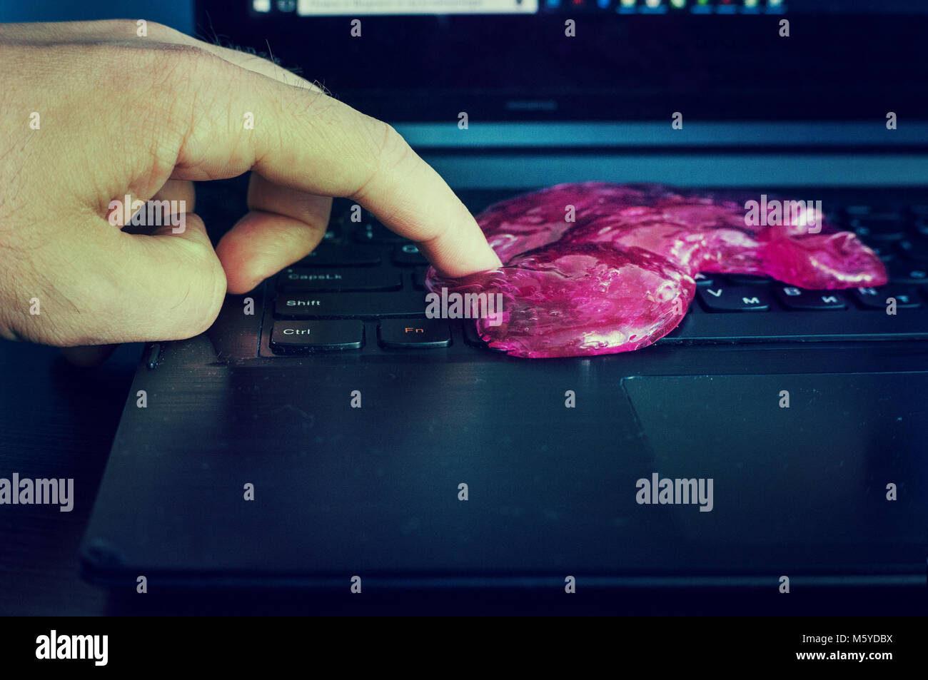 Red soft gel polvere pulizia in mano. La pulizia della tastiera del computer. Foto Stock