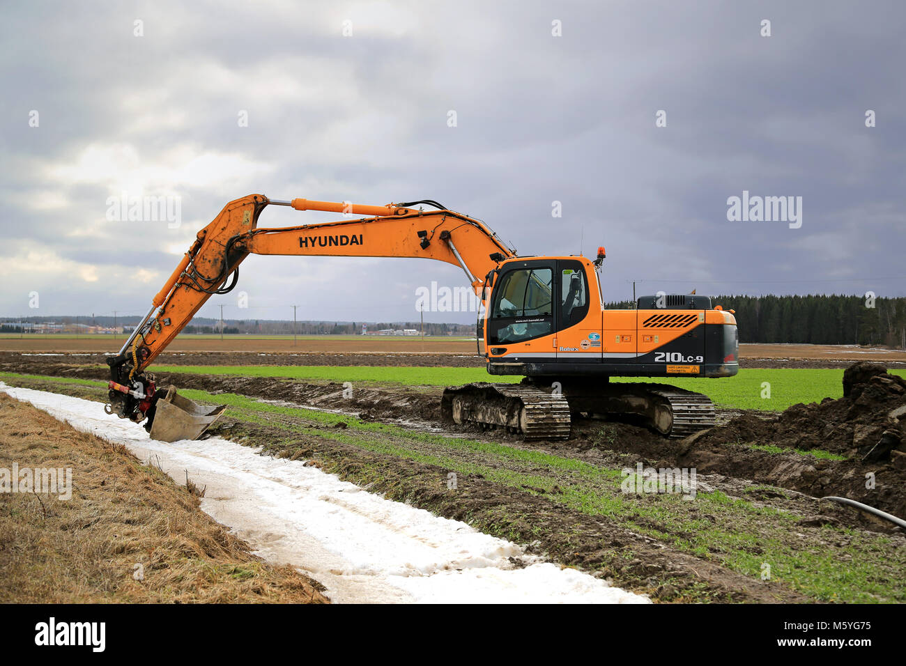 AURA, Finlandia - 1 Marzo 2015: Hyundai Robex 210 LC-9 Escavatore cingolato su un campo. L'R210LC-9 ha estensione in senso orizzontale di 10,9 m e dregding profondità di Foto Stock
