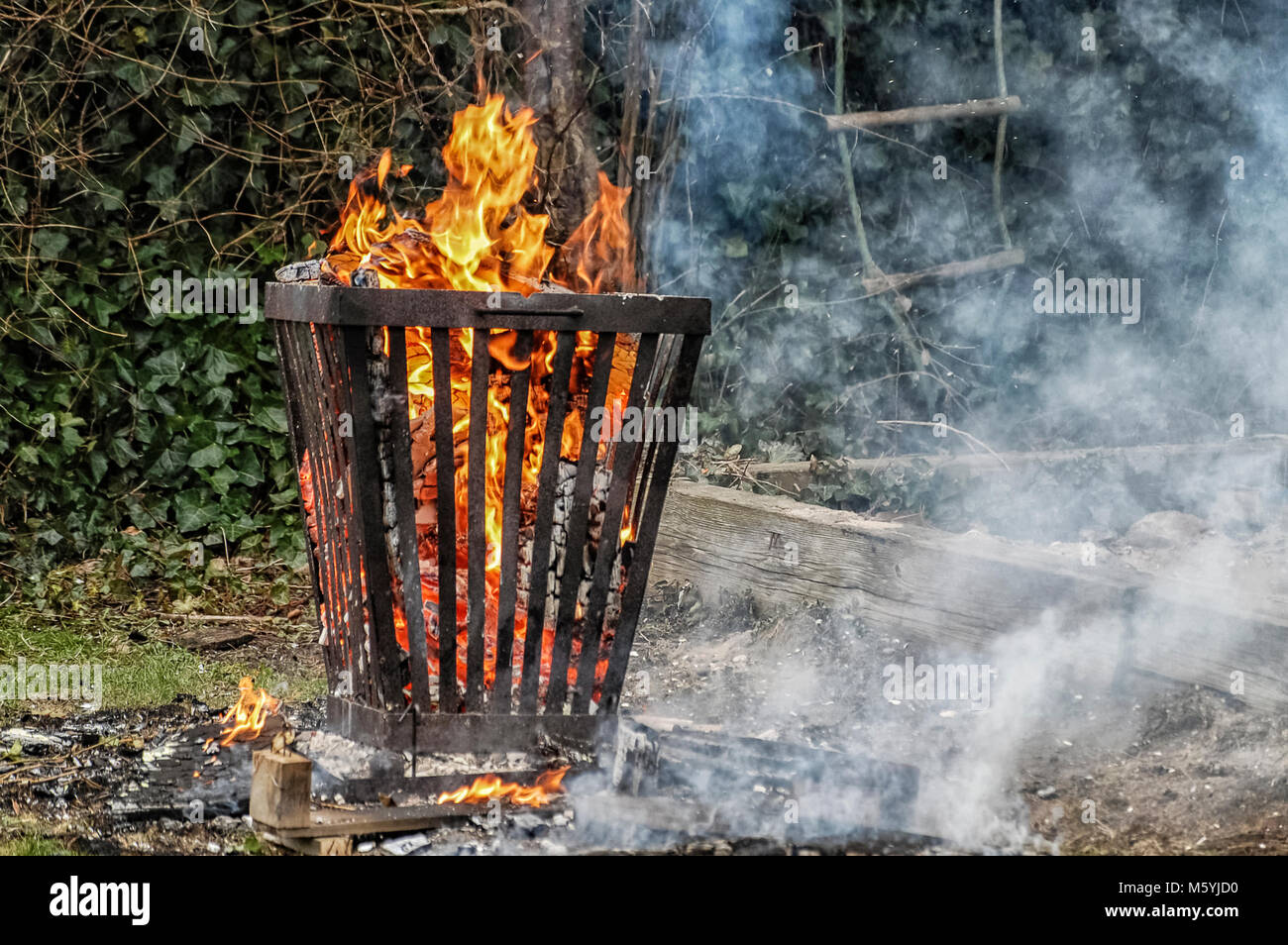 Un fuoco che brucia il cestello con un sacco di fumo Foto Stock
