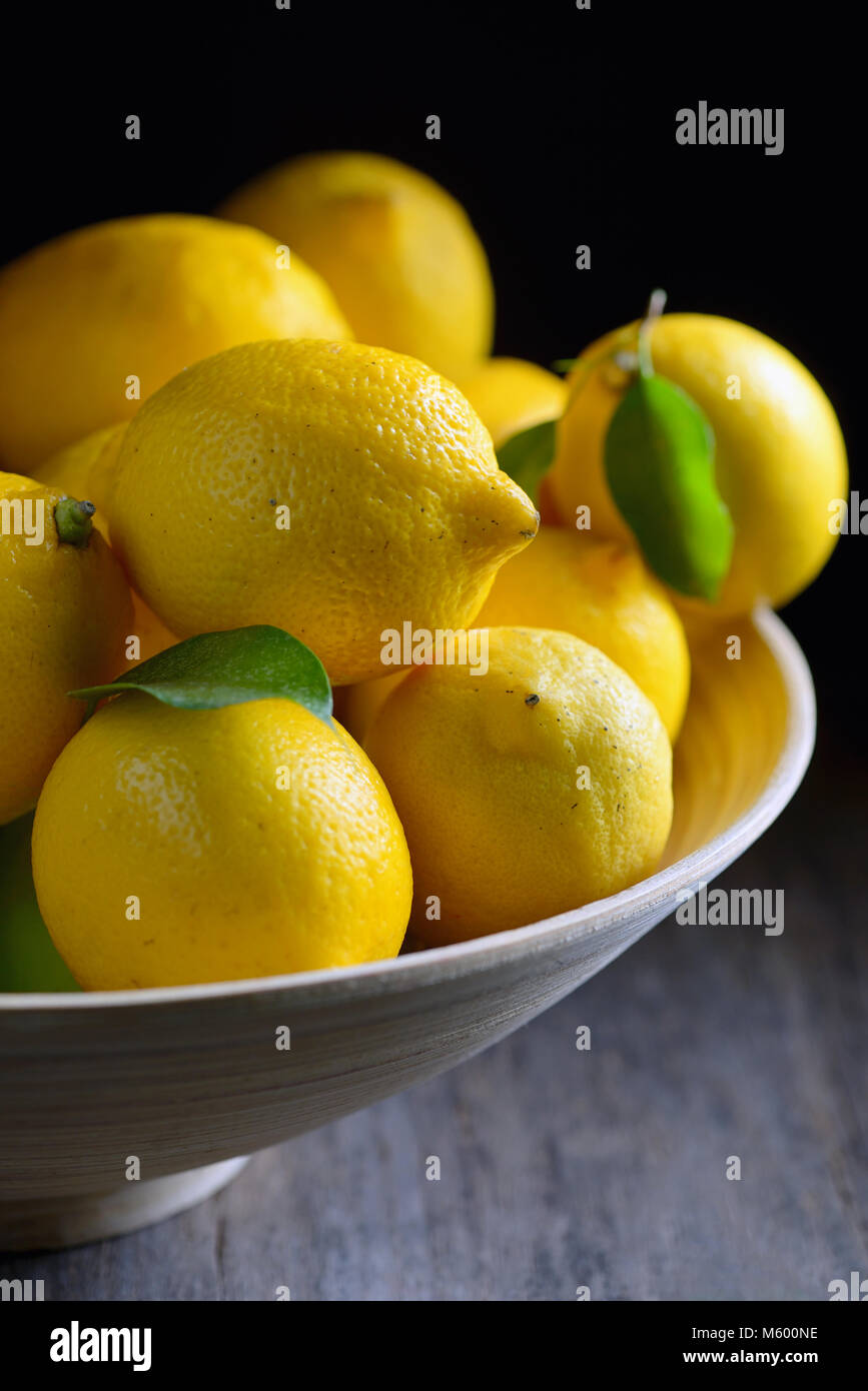 I limoni con foglie su un vecchio tavolo in legno Foto Stock