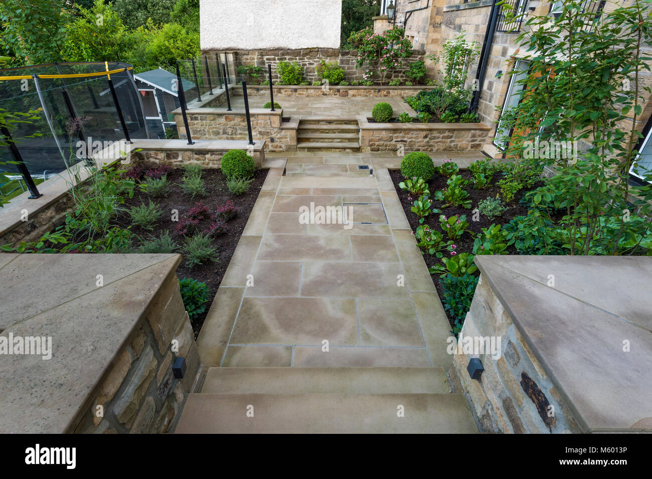 Piccolo angolo della bella e paesaggistici, giardino privato con un design contemporaneo, sentiero lastricato e passaggi di frontiera, arbusti e piante - Yorkshire, Inghilterra, Regno Unito. Foto Stock