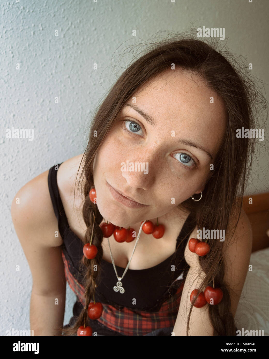 Blue-eyed girl con ciliegie in trecce Foto Stock