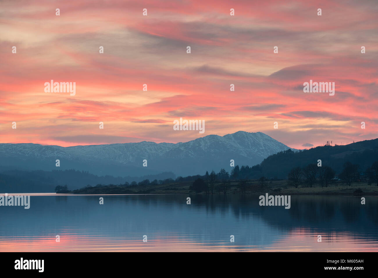 Il sole tramonta dietro Ben Venue all'estremità occidentale del Loch Venachar Foto Stock