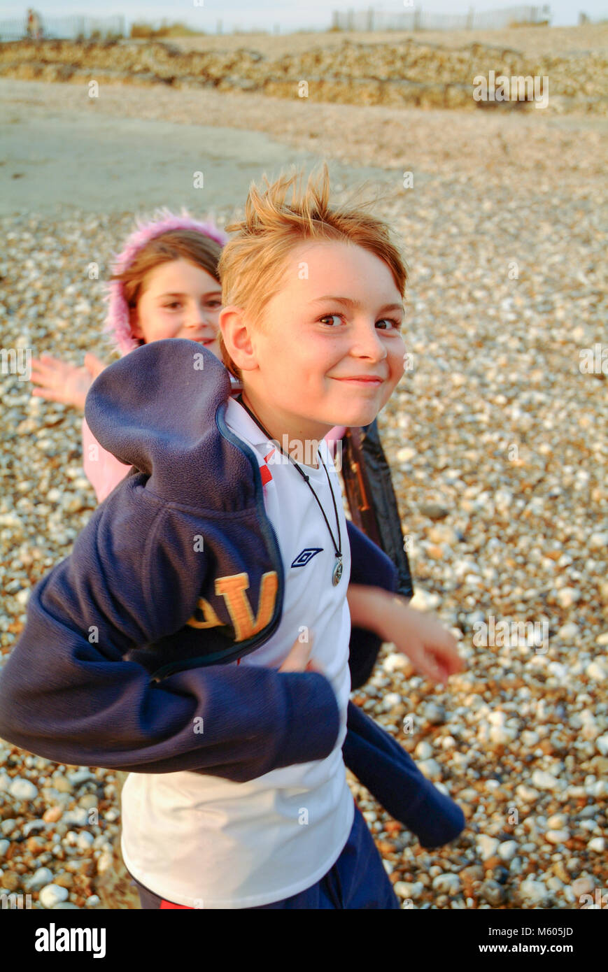 Bambini Un ragazzo e una ragazza si gioca su una spiaggia ghiaiosa Foto Stock