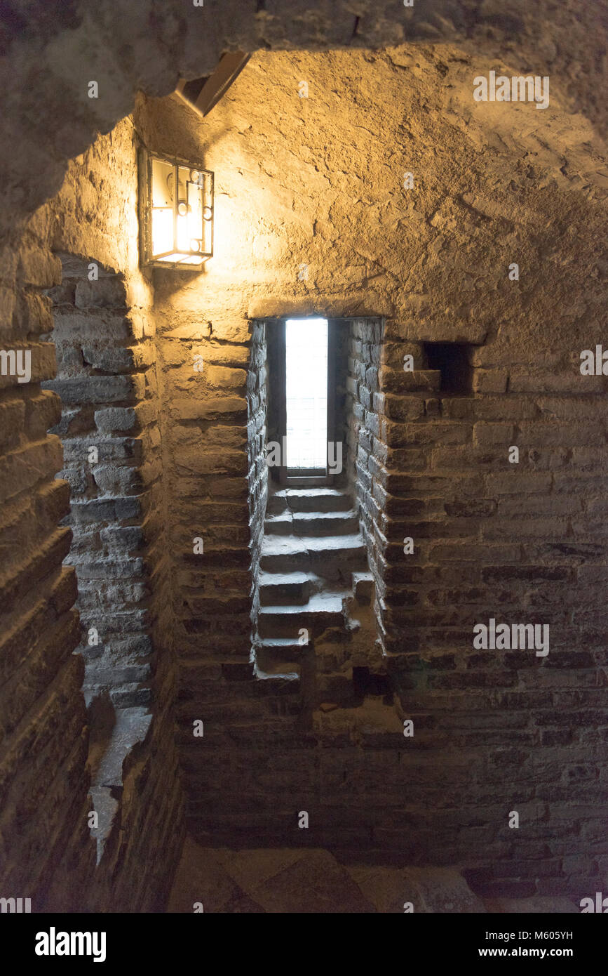 Interni in pietra con finestra di un vecchio campanile cripta, situato all'interno di una antica chiesa cattolica Foto Stock