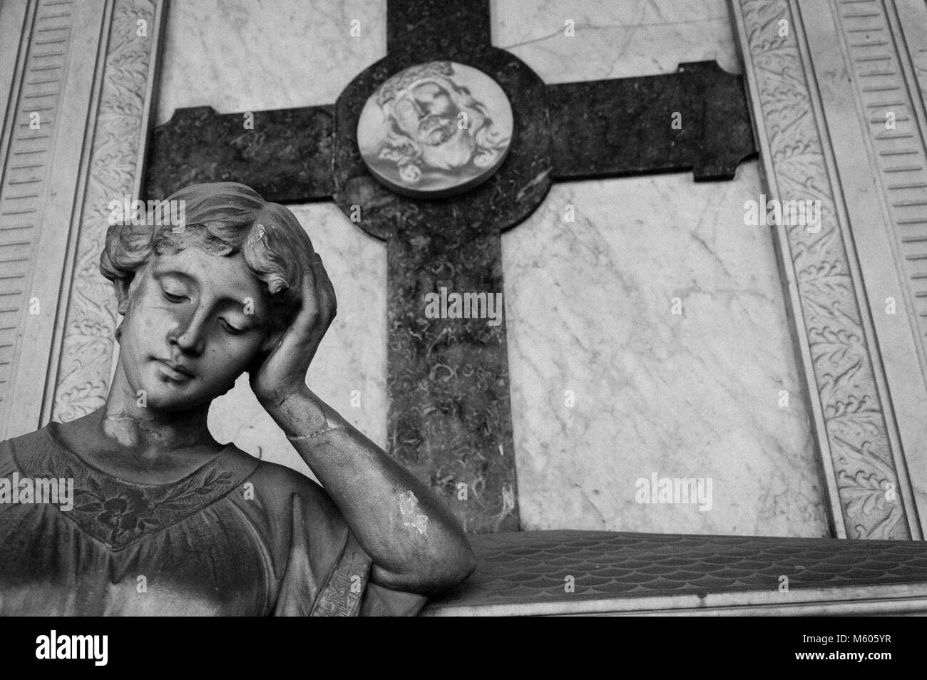 Preoccupato donna immerso in un profondo pensiero statua, con icona di Cristo sullo sfondo Foto Stock