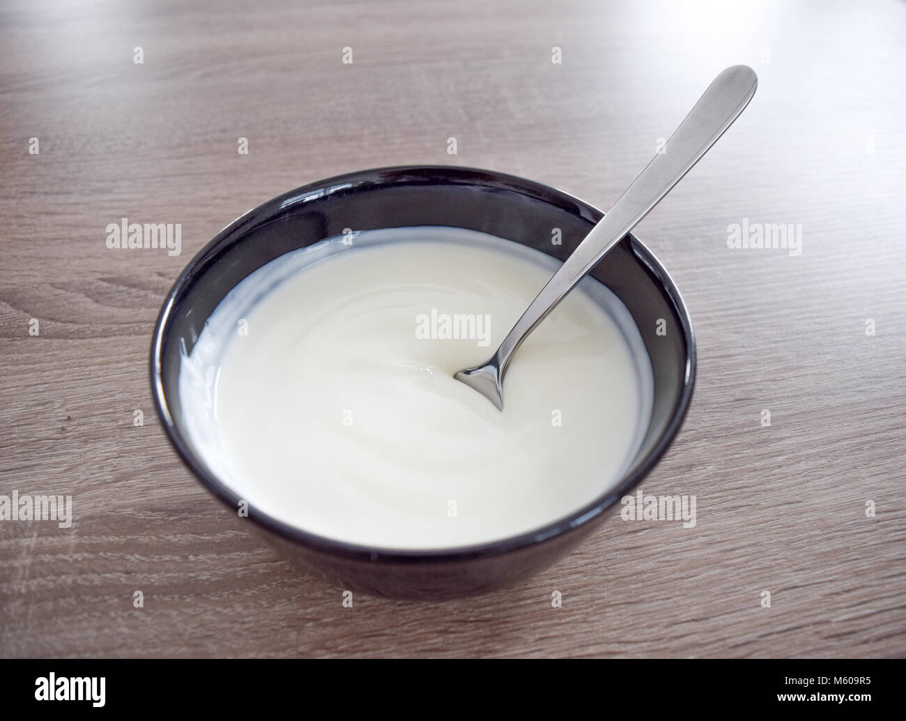Vaso in ceramica di yogurt bianco isolato su sfondo di legno e cucchiaio con yogurt vista da sopra, Yogurt Yogurt Yogurt Foto Stock