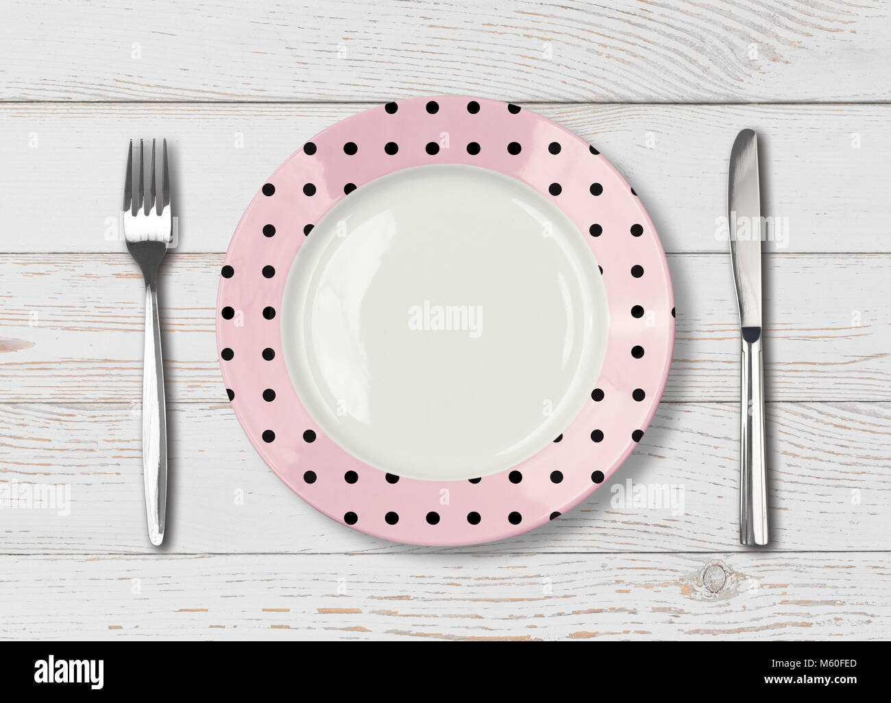 Vista superiore del vuoto pink polka dot piatto sul tavolo di legno Foto Stock