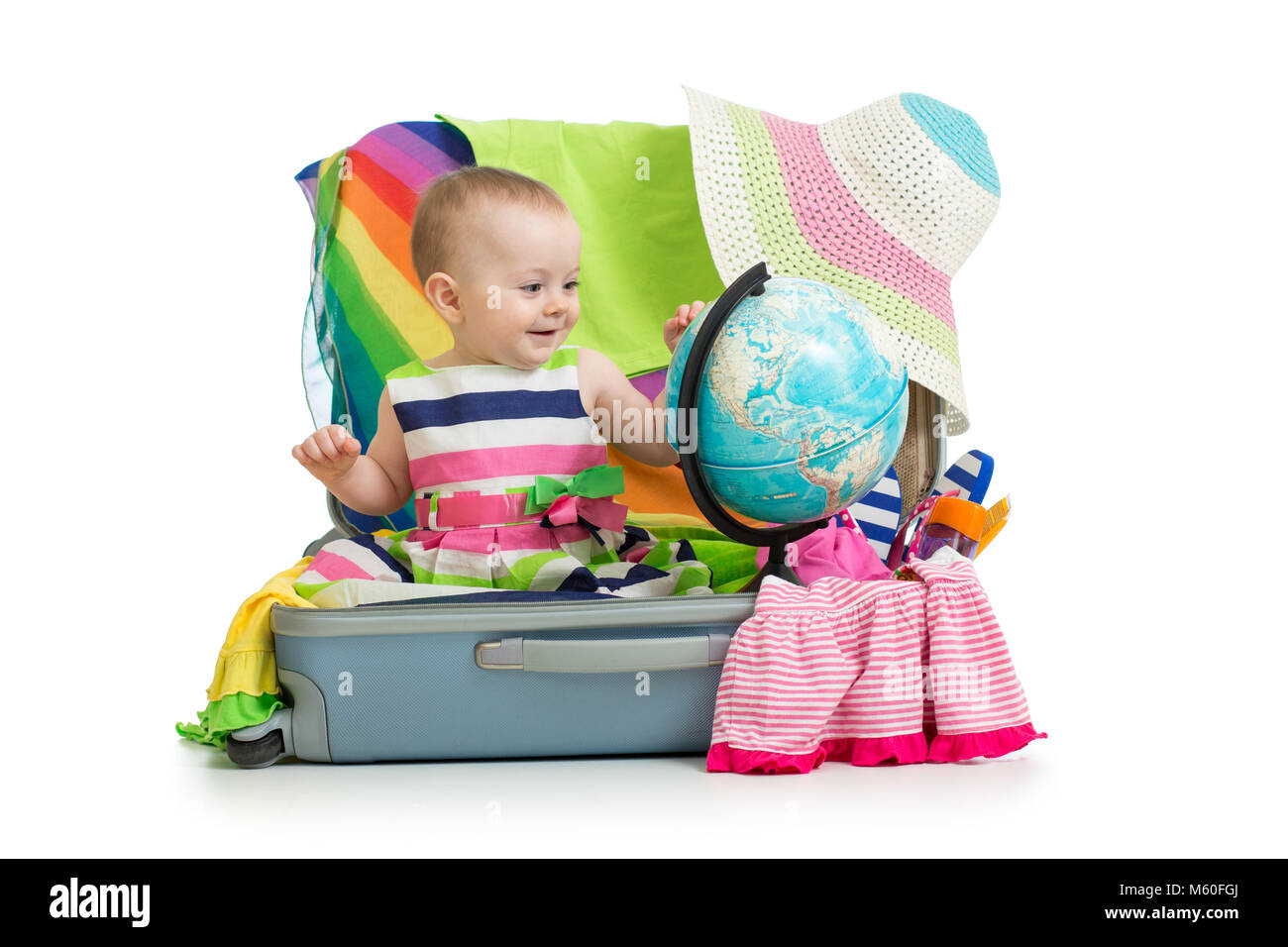 Avventura. Baby preparando per il viaggio. Il bambino si siede in valigia e guarda al mondo. Foto Stock