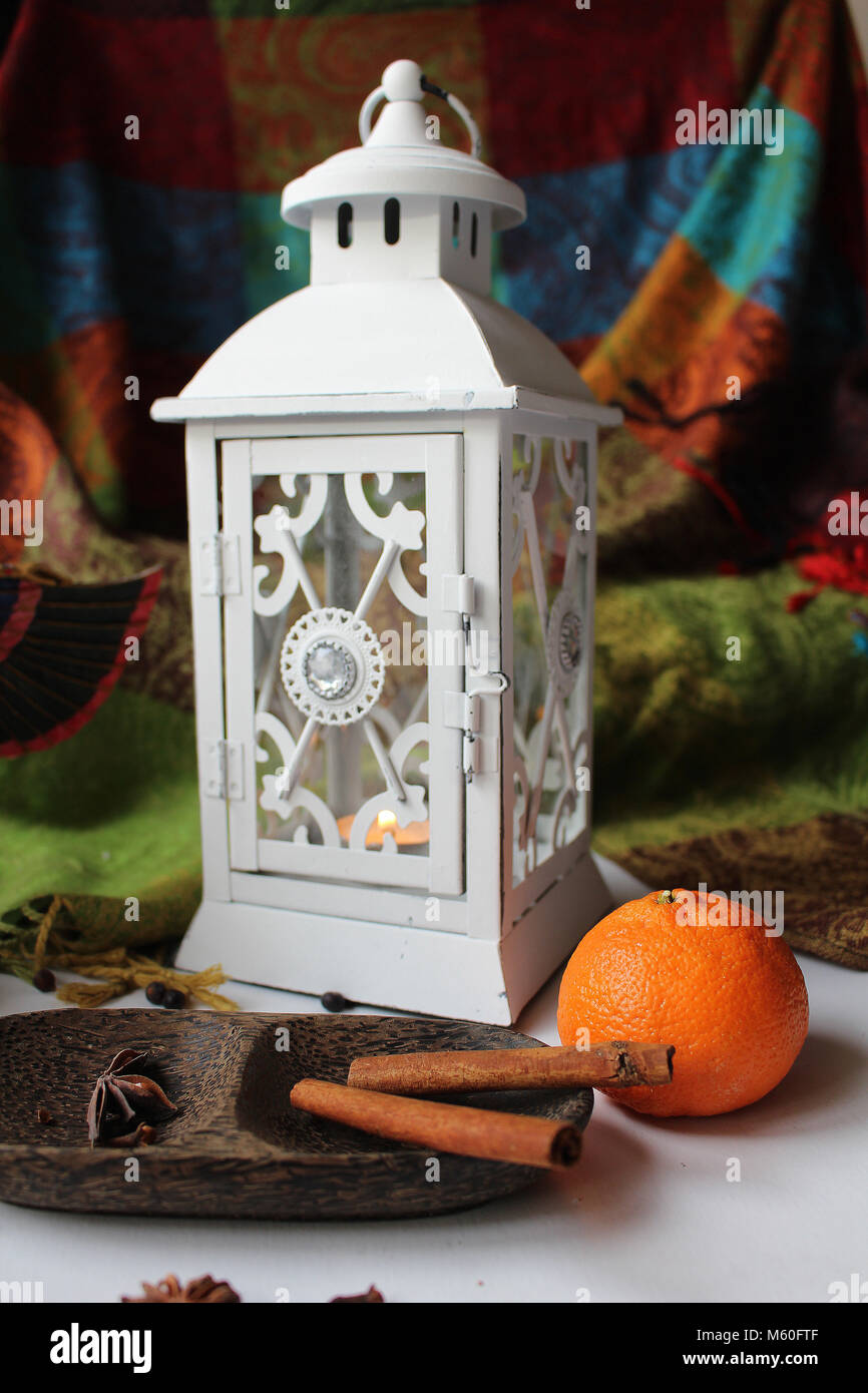 Still Life - bianco lampada vintage disposto su una tavola con un mandarino e spezie sulla ciotola di legno Foto Stock