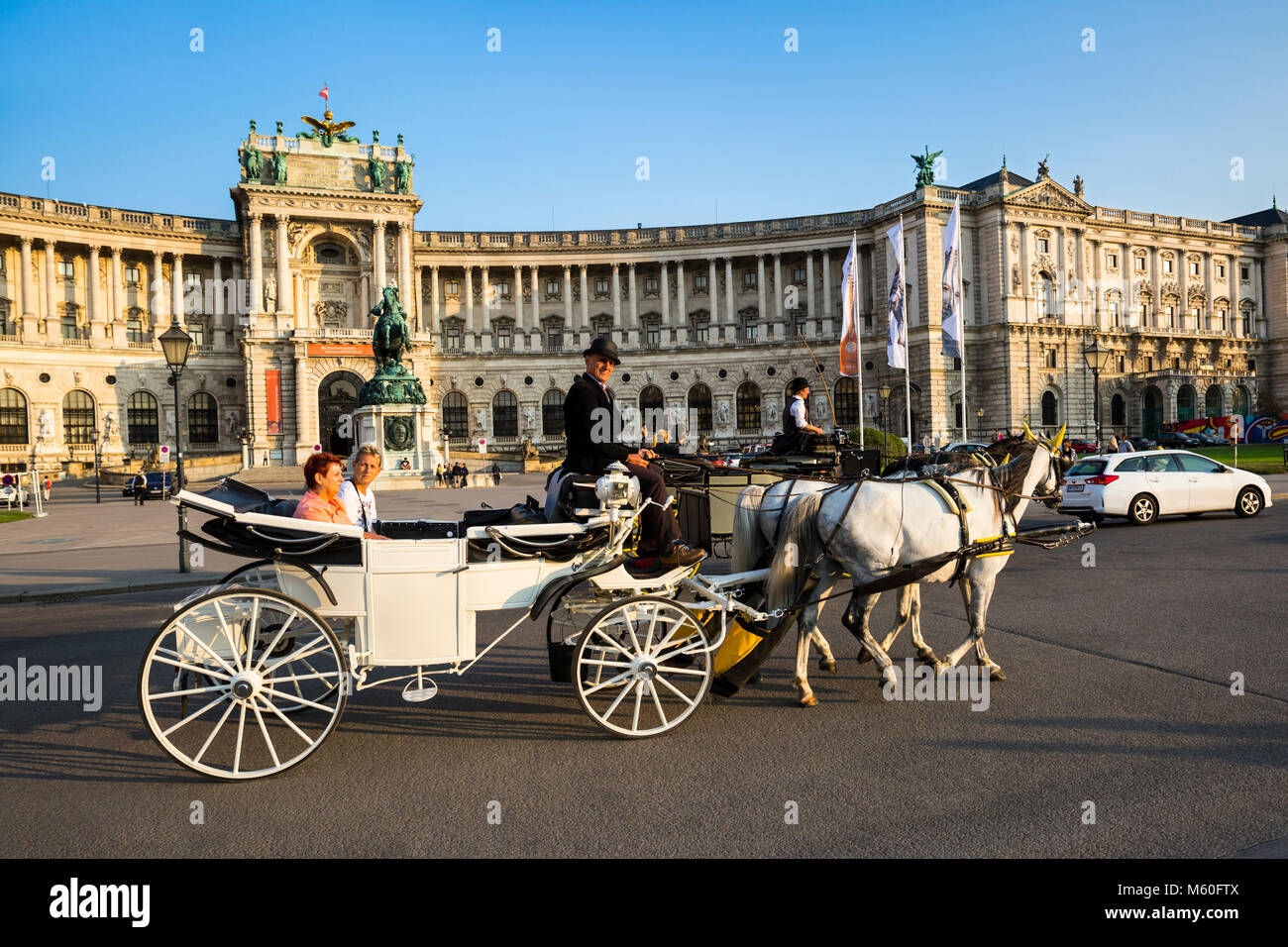Turisti che si godono una passeggiata in carrozza passato del palazzo di Hofburg, Wien, Vienna, Austria. Foto Stock