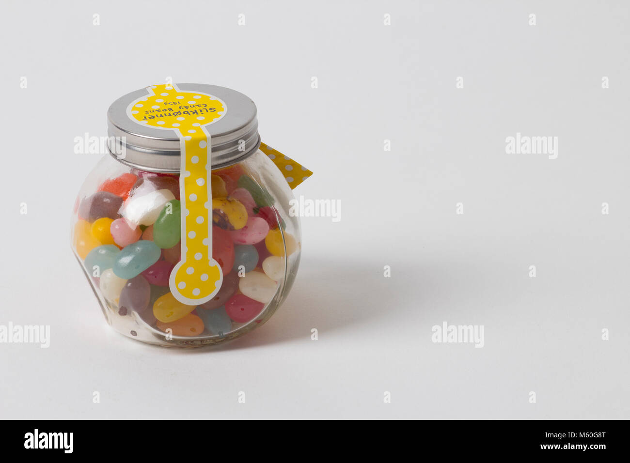 Jellybeans nel vasetto di vetro su sfondo bianco Foto Stock
