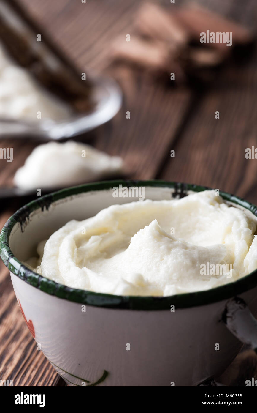 In casa la glassa di formaggio cremoso in tazza rurale su tavola in legno rustico pronto per l'uso Foto Stock