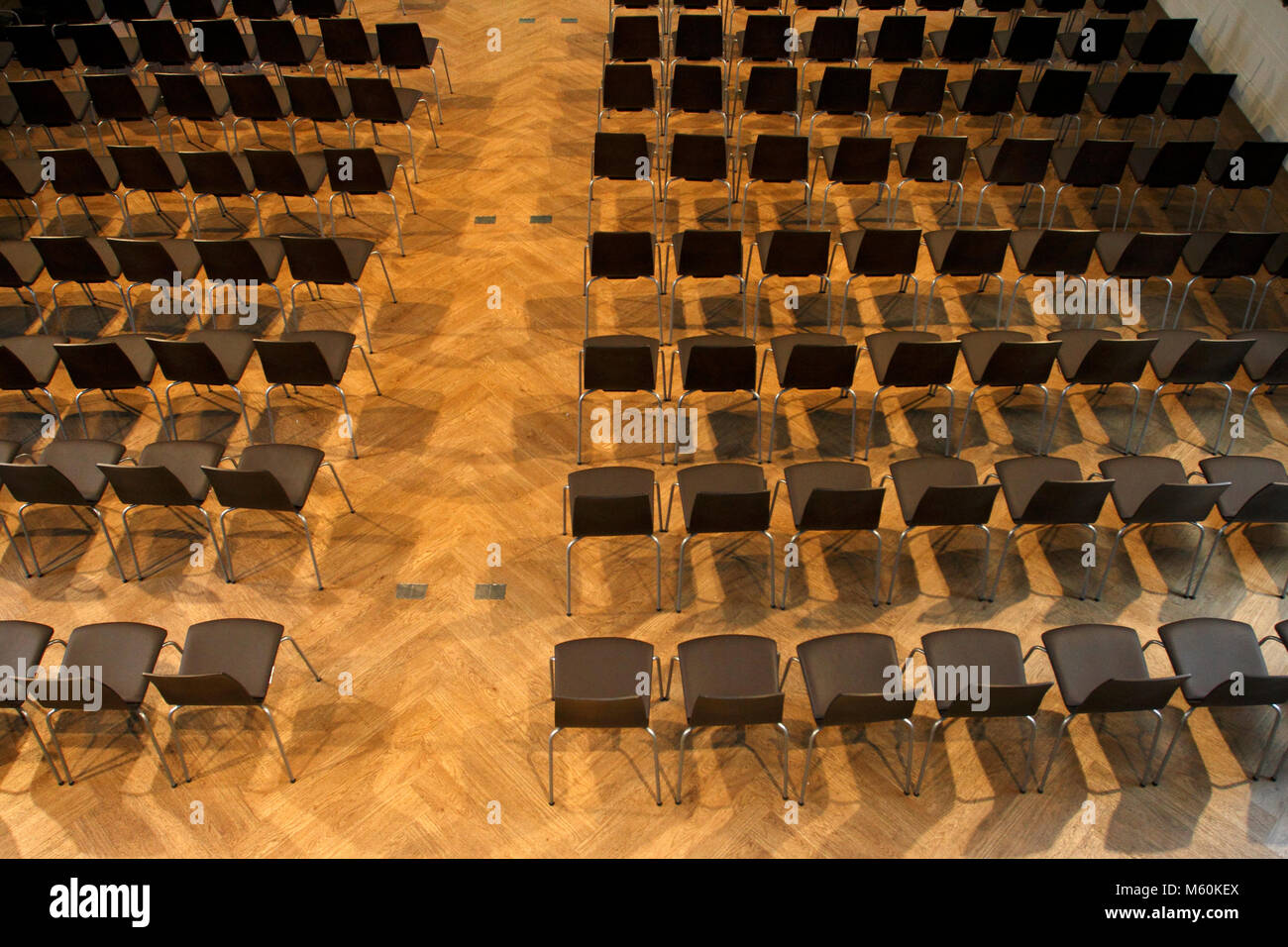 Sedie in fila su di un pavimento in legno, per un concerto, una performance, o una conferenza. Foto Stock