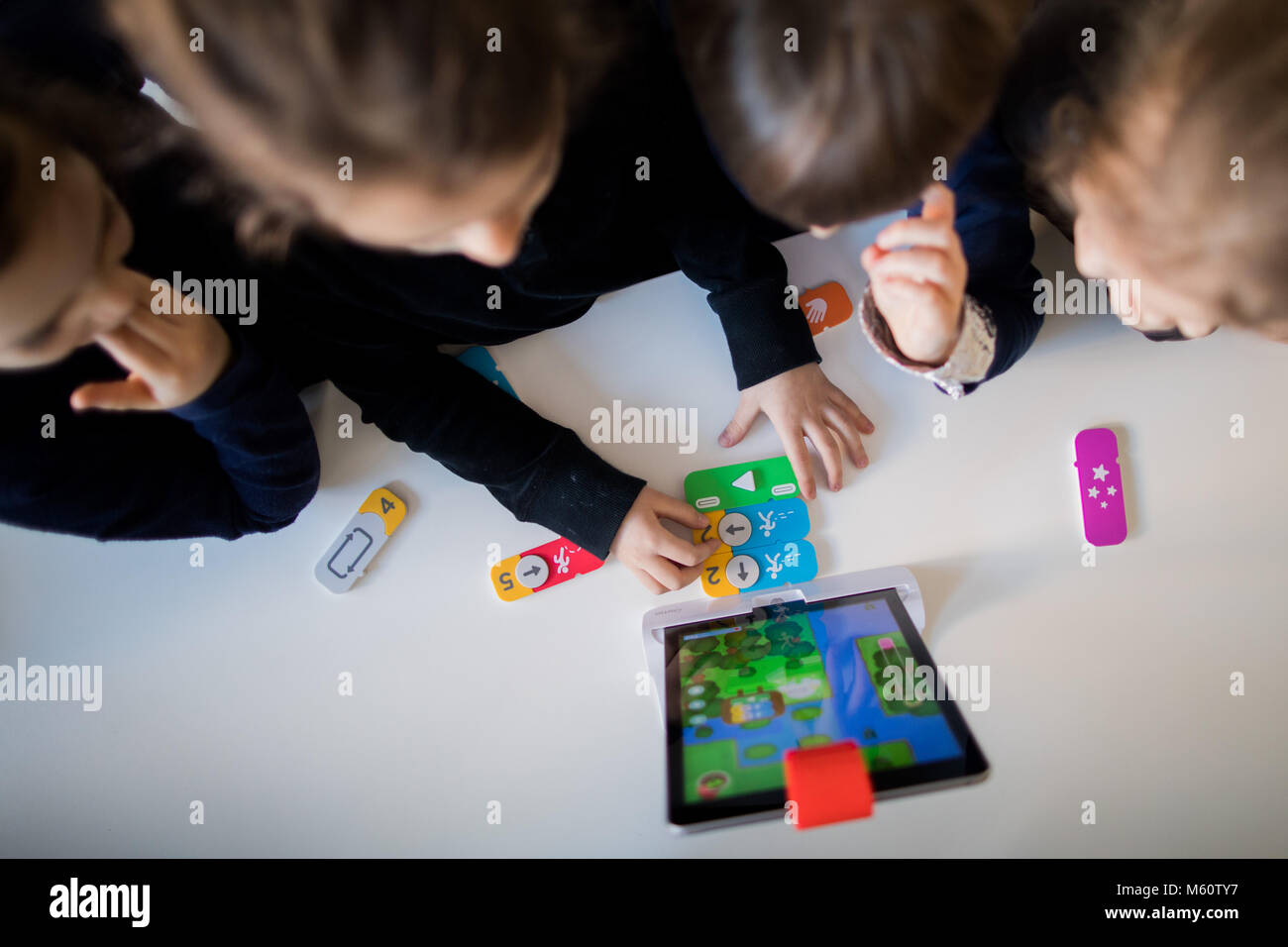 27 febbraio 2018, Germania, Duesseldorf: Bambini all'asilo nido "eepferdchen' (lit. cavallucci marini) imparare la codifica in un modo divertente. I bambini si spostano un mostro su un iPad eseguendo i comandi di programmazione digitale con mattoni di edificio. Foto: Rolf Vennenbernd/dpa Foto Stock