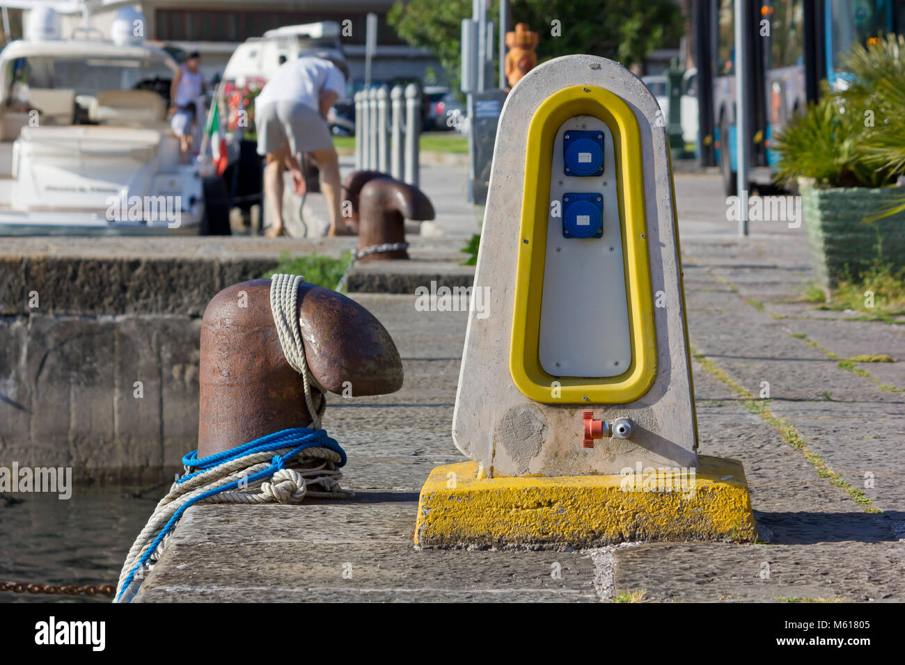 Acqua ed elettricità colonnina di distribuzione su un molo vicino a un bollard Foto Stock