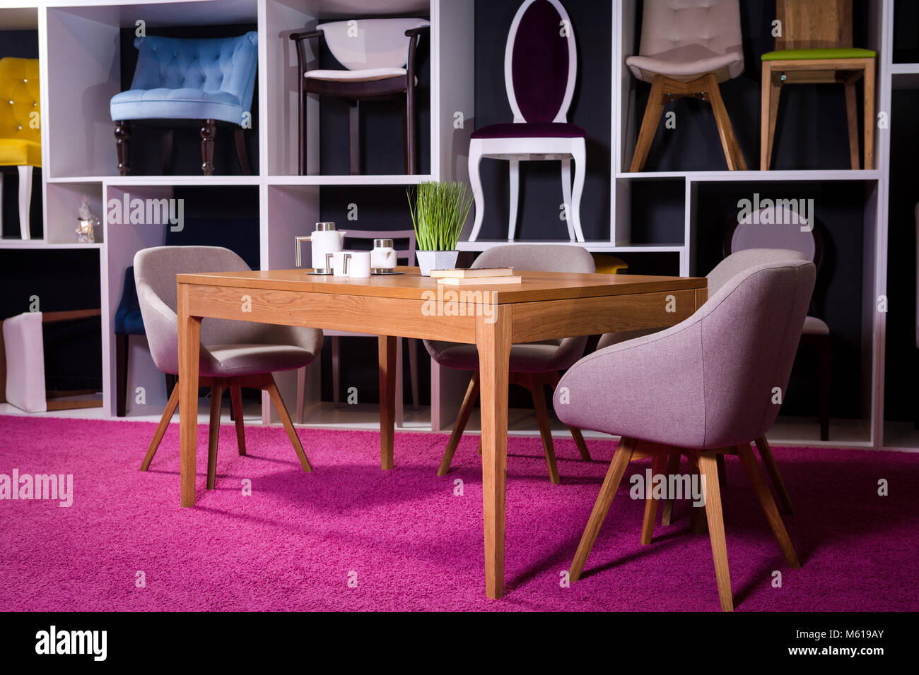 Shop, vendita di mobili in un centro commerciale. Campione di esposizione da pranzo tavolo in legno con sedie di tessili in grigio su un ripiano bianco con mobili e di un Foto Stock