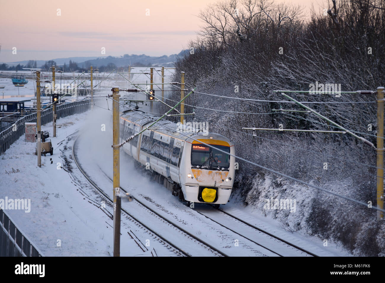 Treno nella neve. C2C convoglio ferroviario in esecuzione attraverso la coperta di neve linee in Chalkwell vicino a Southend on Sea, Essex durante la Bestia da est meteo Foto Stock