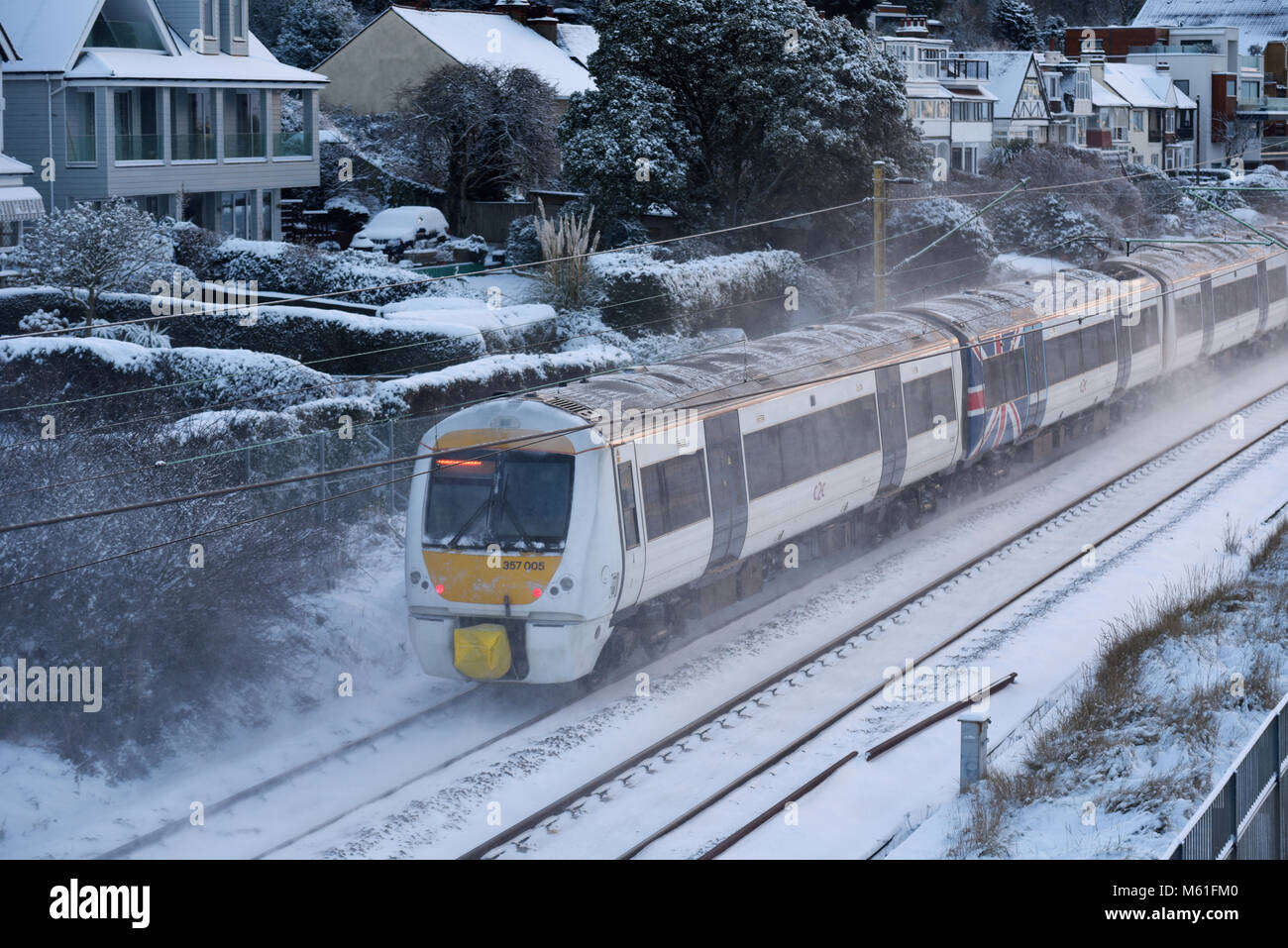 Treno nella neve. C2C convoglio ferroviario in esecuzione attraverso la coperta di neve linee in Chalkwell vicino a Southend on Sea, Essex durante la Bestia da est meteo Foto Stock