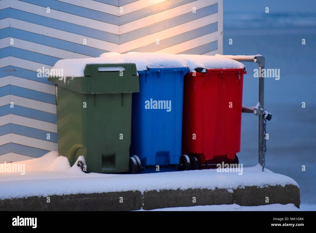 Spazzatura multicolore e bidoni per il riciclaggio coperti di neve sul lungomare Southend on Sea. Multicolore Foto Stock