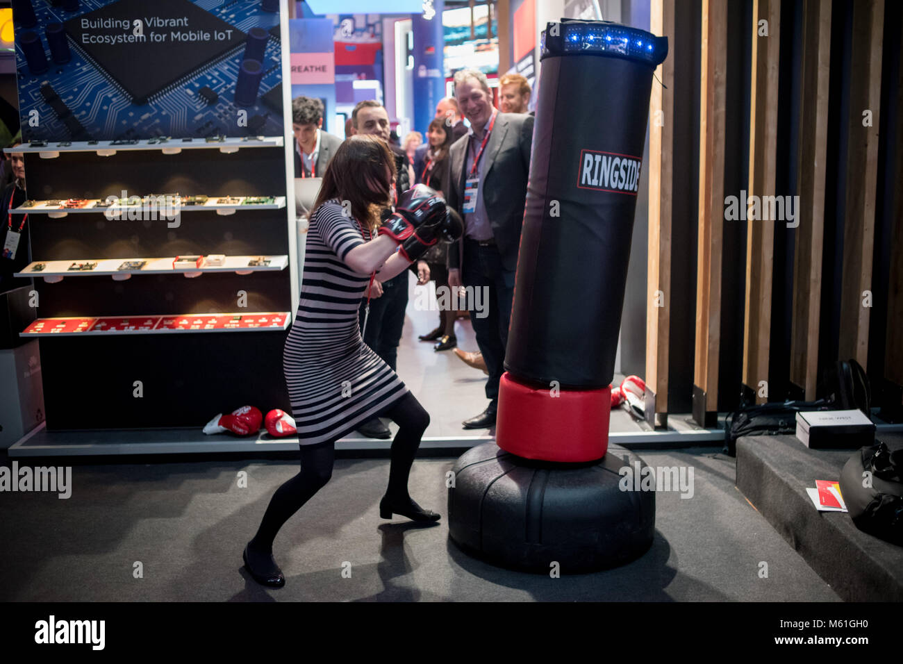 Una donna colpisce un sacco da boxe dotata di sensori durante il secondo  giorno dell'annuale Mobile World Congress, il mondo è più grande fiera del  mobile in cui brin Foto stock -