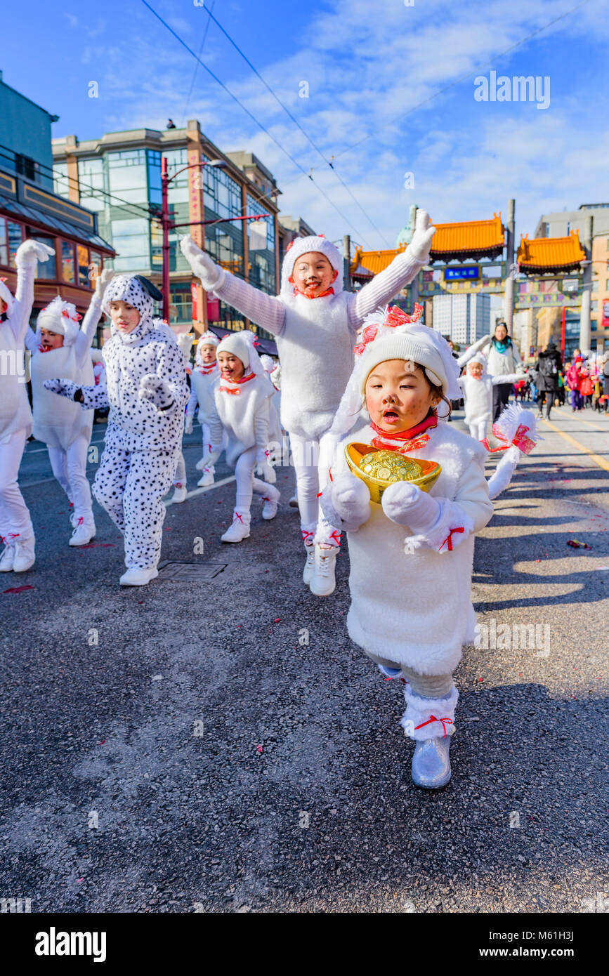 Bambini raffiguranti piccoli cani danza nel nuovo anno lunare cinese Parade, Chinatown, Vancouver, British Columbia, Canada. Foto Stock