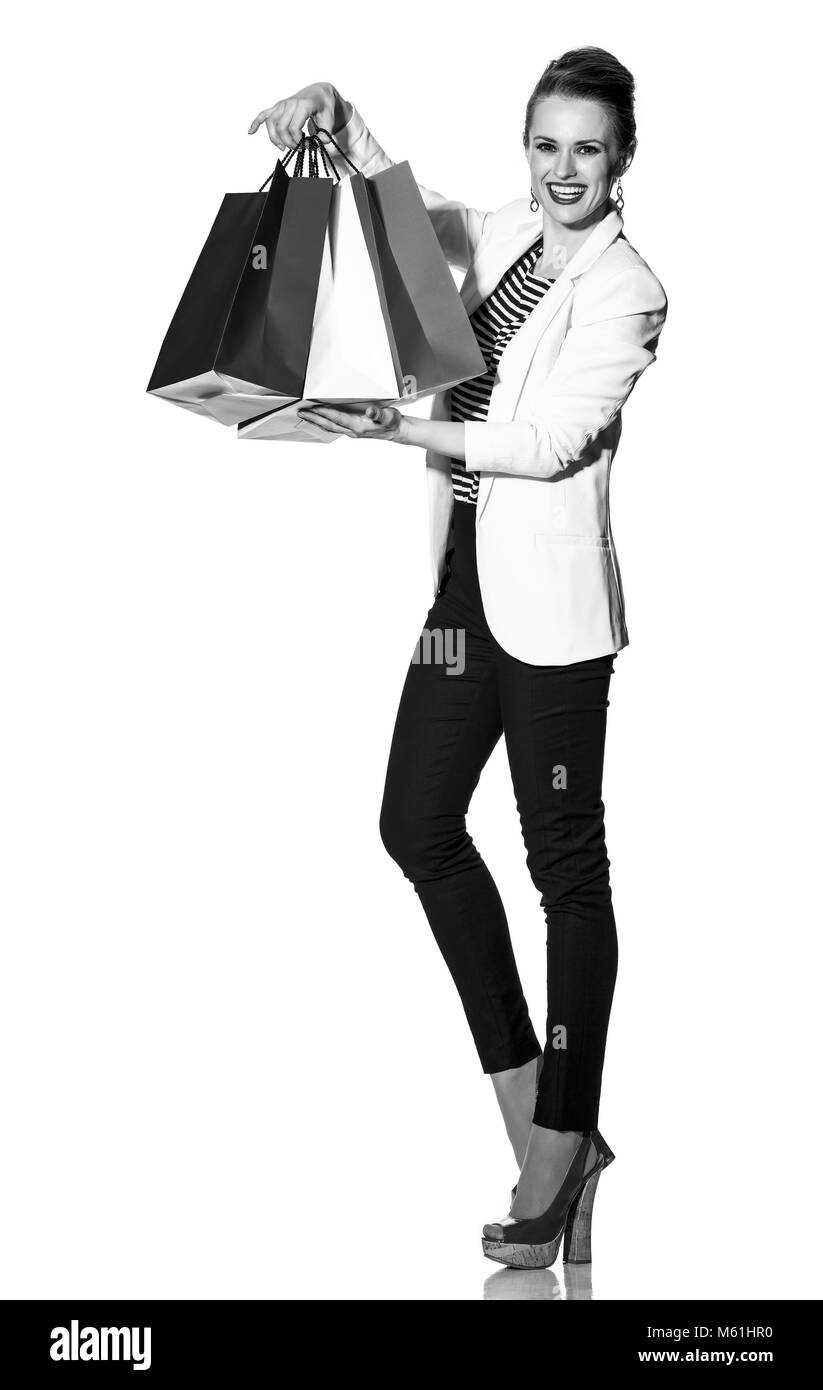Lo Shopping di lusso. Il modo francese. A piena lunghezza Ritratto di felice alla moda donna in camicia bianca isolata su bianco che mostra shopping bags verniciato in col Foto Stock