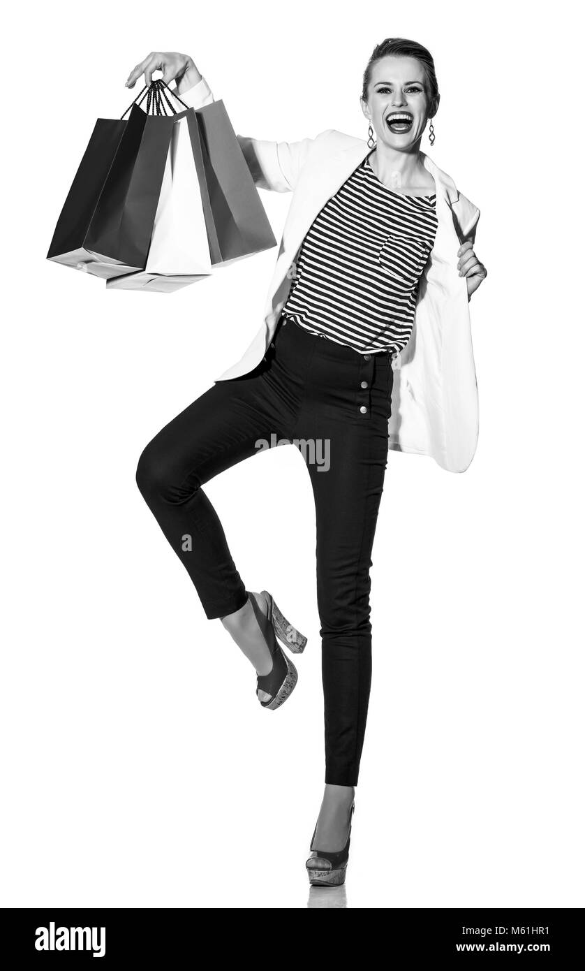 Lo Shopping di lusso. Il modo francese. A piena lunghezza Ritratto di felice moda giovane-monger in camicia bianca isolata su bianco che mostra le borse della spesa dipinto in Foto Stock