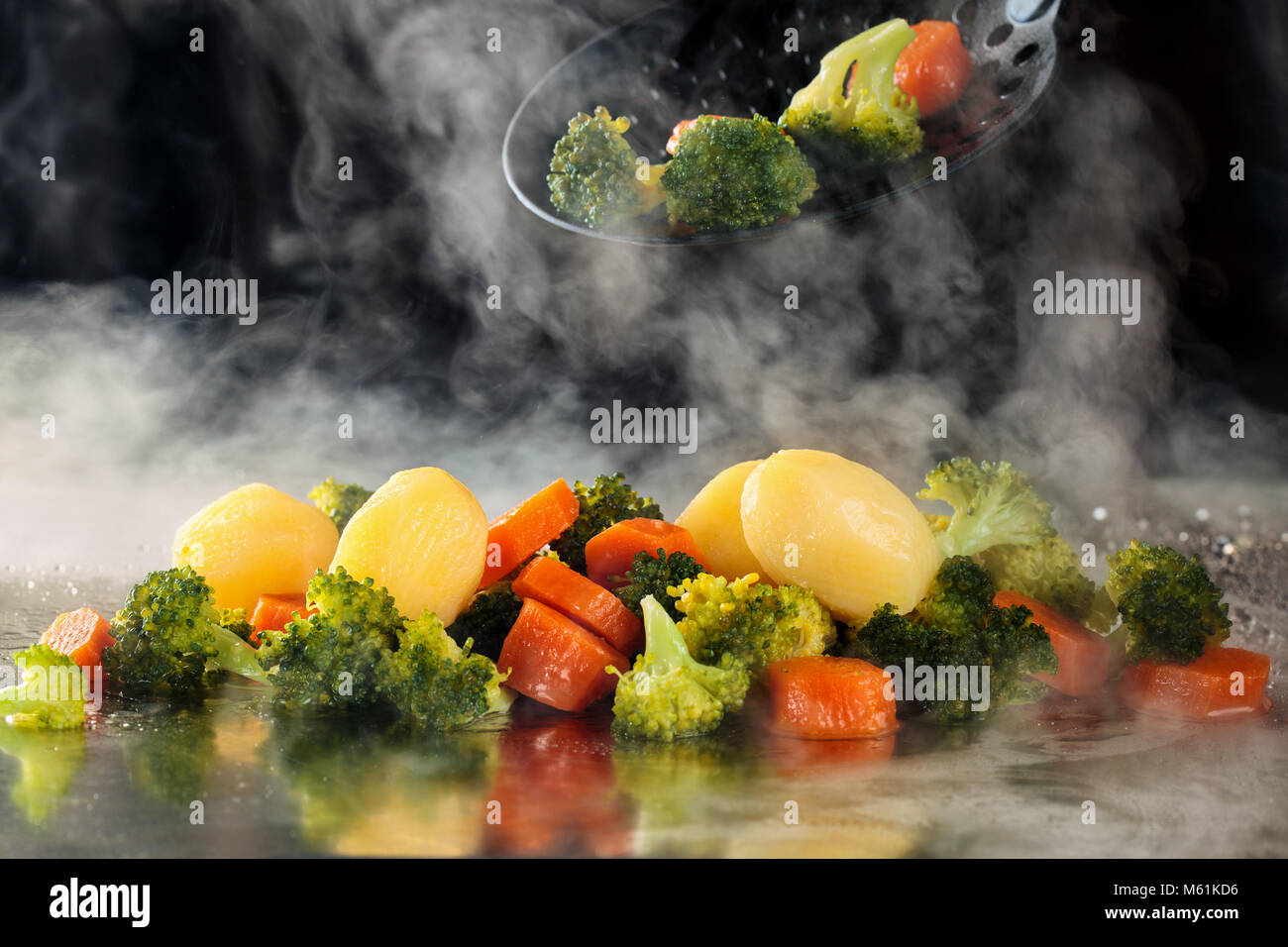 Closeup shot di verdure cotte al vapore sul vassoio con il vapore. Foto Stock